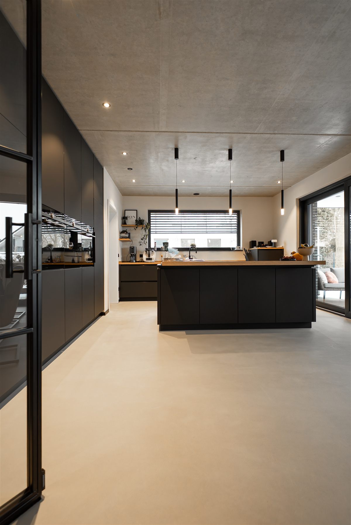Moderne Wohnküche mit fugenlosem Boden und Sichtbeton-Decke, eine Lamurista Referenz